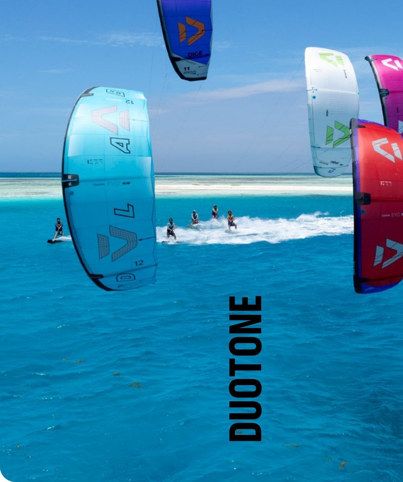 Group of 2027 Duotone kites over flat turquoise water