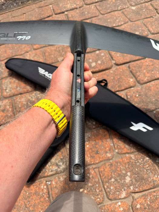 F-one Eagle 990 HM Carbon connection bar held up showing 3-hole Titan fitting and metallic fuselage adapter plate