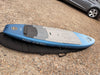 North Midi 6'4 96L wing foil board, side rail profile resting on its Mystic padded board bag