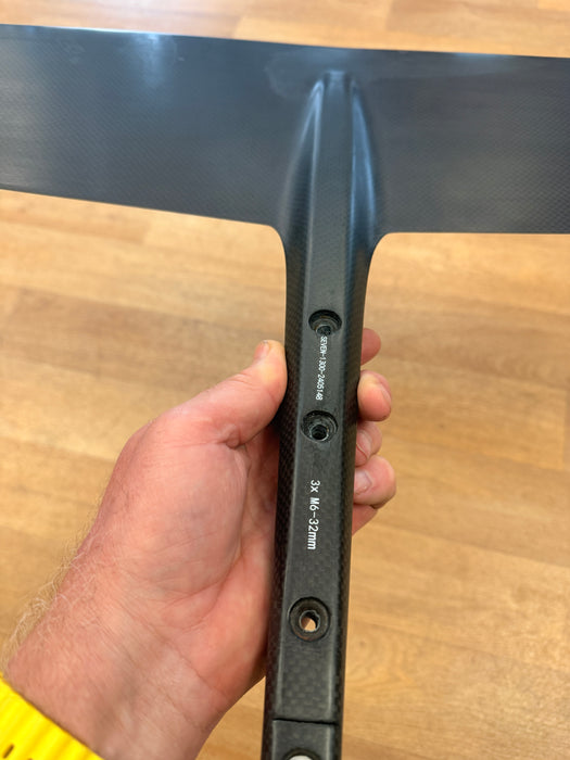 F-One Seven Seas Carbon fuselage held in hand showing the foil mounting hardware