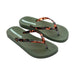 Pair of green flip-flops with tortoiseshell straps on a white background