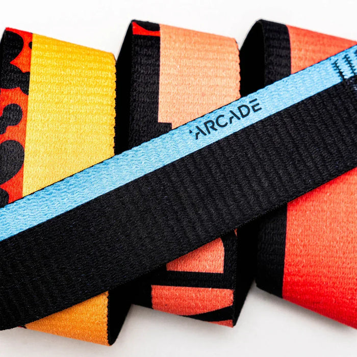 Arcade Sierra Acid Fade belt in orange, yellow, and black with blue accent, close-up