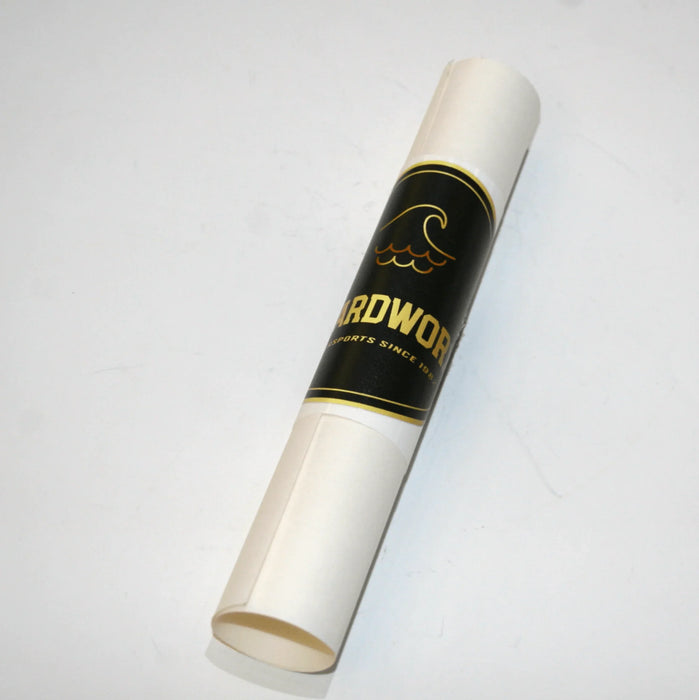 Rolled kitesurf bladder repair patch with black and gold label, wave graphic visible.