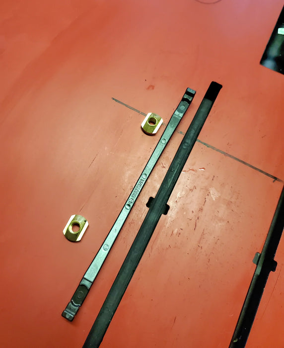 Duotone wing foil track nuts and sled on an orange board, close-up hardware view