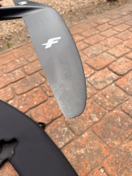 Close-up of wingtip of used F-one Sk8 V2 850 showing F-one lightning bolt logo and surface scuffs near trailing edge — disclosed cosmetic marks