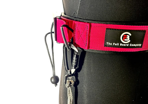 The Foil Board Company red waist leash belt with black carabiner and cord, worn over wetsuit