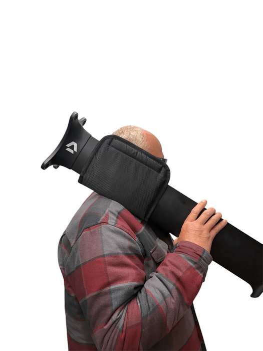 Black carry pad with shoulder saver for paddleboard or surfboard, shown in use on shoulder