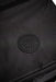 Close-up of black watersports gear bag with vented drainage panel, durable fabric visible