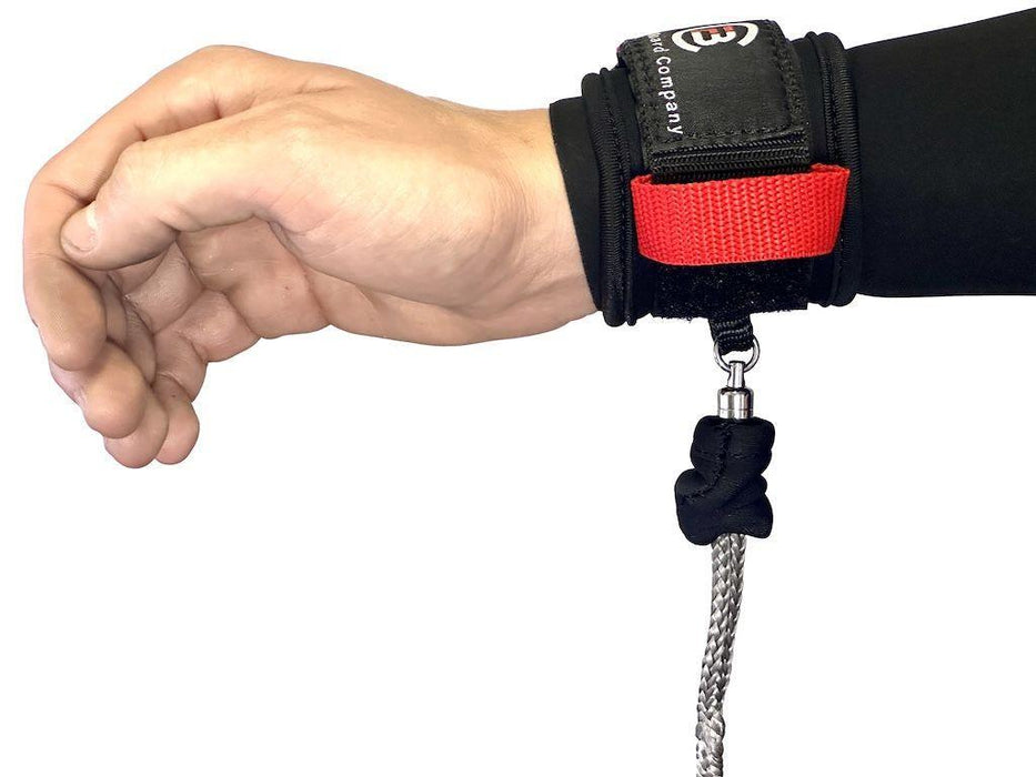 Black and red wrist wing foil leash with logo, worn on hand, braided rope attachment.