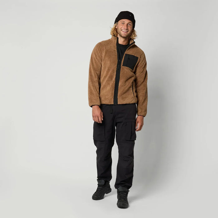 Man wearing brown zip-through fleece jacket with black pocket, black cargo pants, and beanie