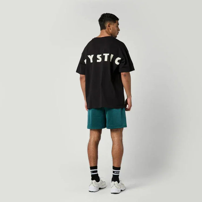 Mystic black t-shirt with large logo on back, surf clothing, model standing