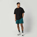 Mystic black profile tee with chest logo, worn with teal board shorts, watersports clothing
