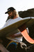 O'Neill O'Riginals black cap with logo, surfer in sunglasses, holding surfboard outdoors