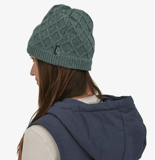 Patagonia green knit beanie with diamond pattern, worn with navy vest