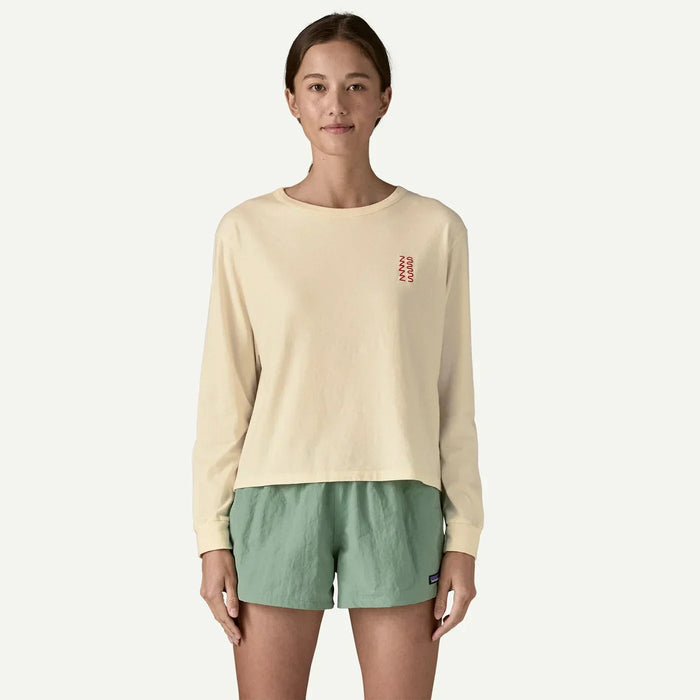 Woman wearing cream long-sleeve Patagonia organic shirt and green board shorts