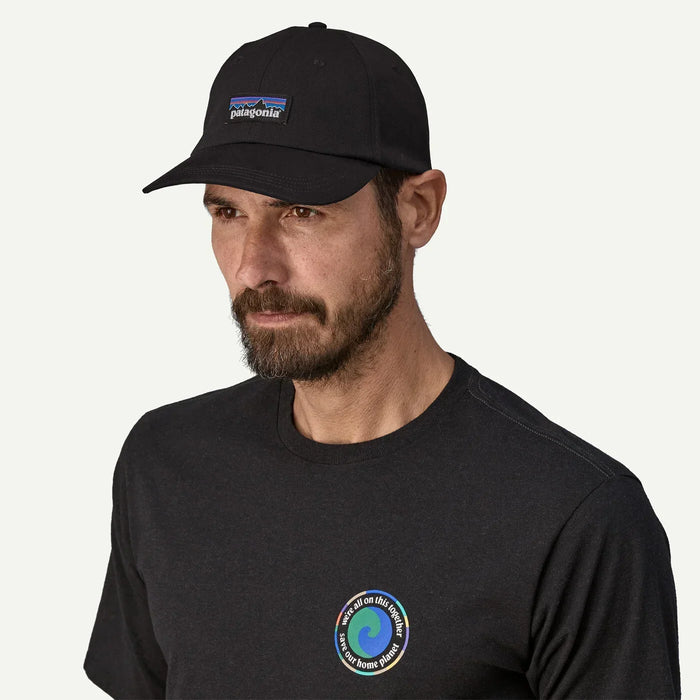 Patagonia black cap with P-6 label on man, surf t-shirt, surf clothing accessory