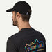Patagonia P-6 Label Trad Cap in black, adjustable strap, worn by man with Patagonia logo shirt