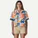 Woman wearing Patagonia short sleeve shirt with colourful sardines and wave print, natural colour.