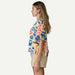 Patagonia tidal threads shirt with sardine print in natural cream, worn by woman in beige shorts