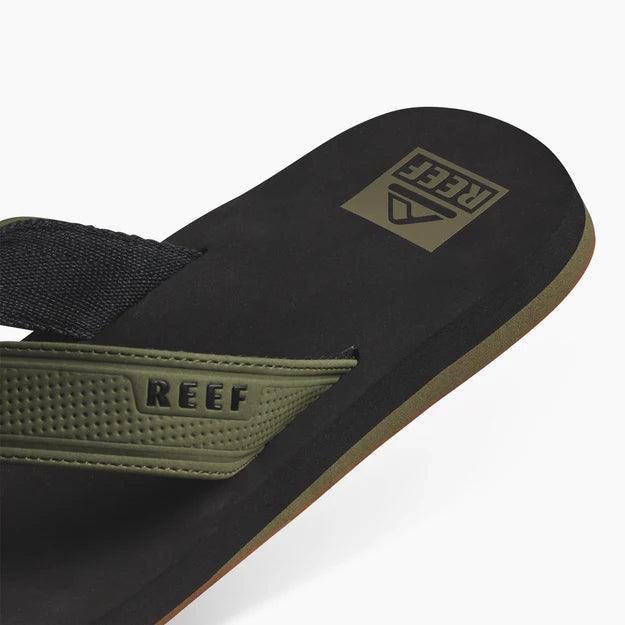 Reef Layback flip flop in black and olive, featuring brand logo and durable strap
