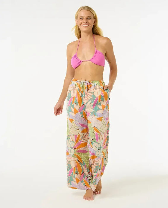 Rip Curl Cala Vadella women’s beach pants with tropical floral print, model standing barefoot
