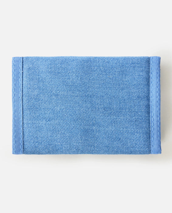 Rip Curl distressed blue denim wallet with visible stitching on white background