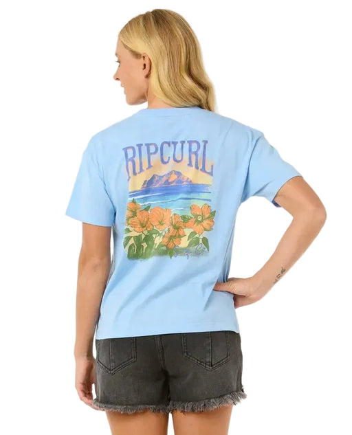 Rip Curl relaxed fit blue tee with floral and beach graphic, worn by woman in black shorts