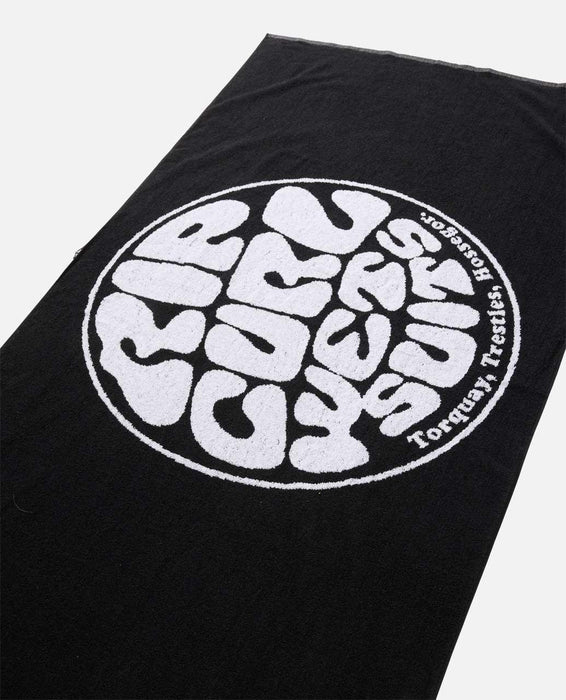 Rip Curl black beach towel with large white logo, ideal for surfing and watersports.