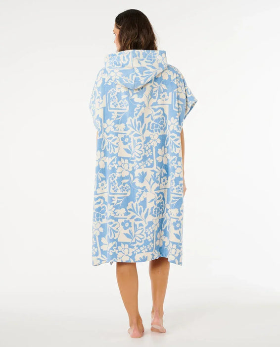 Rip Curl hooded towel poncho in blissful blue with white floral print, worn by woman