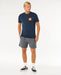 Rip Curl navy stacked tee with logo chest print, worn by man in casual beachwear