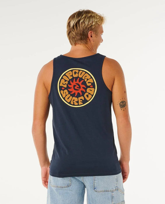 Rip Curl dark navy tank vest with large surf logo on back, worn by man in denim shorts