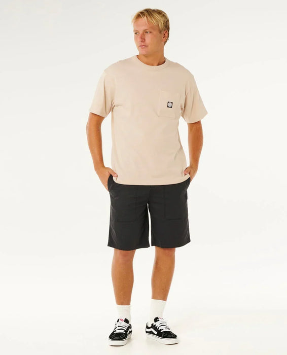 Man wearing Rip Curl Premium Surf Walkshort in washed black and beige t-shirt, standing casually