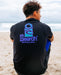Rip Curl black surf tee with blue logo, man sitting on sandy beach near ocean