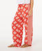 Rip Curl red wide leg pants with white floral print, relaxed beachwear style