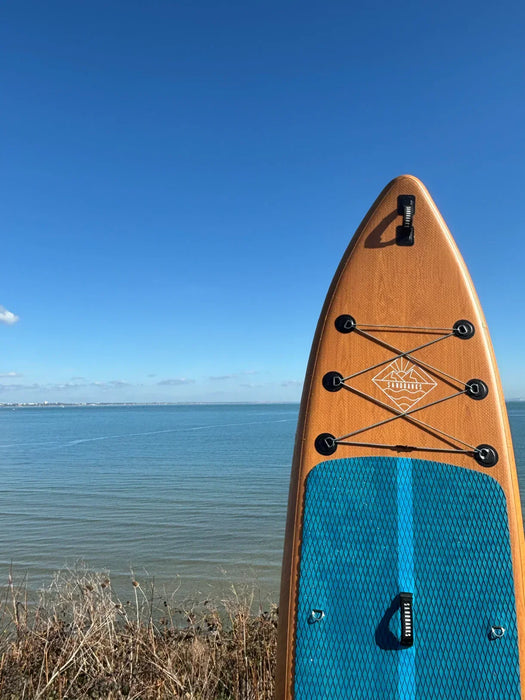 Sandbanks paddleboard with brown and blue deck, bungee storage, by the sea