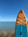 Sandbanks paddleboard with brown and blue deck, bungee storage, by the sea