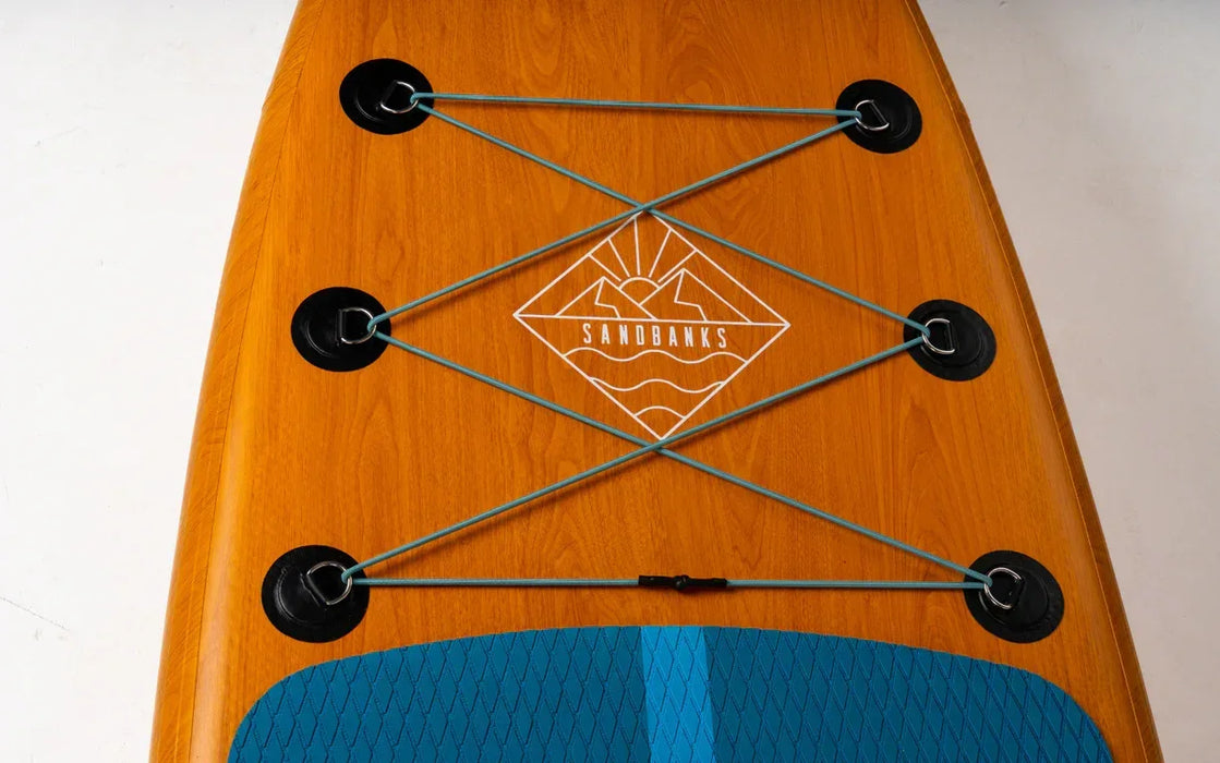 Sandbanks inflatable paddleboard with wood-look finish, blue deck pad and bungee storage cords