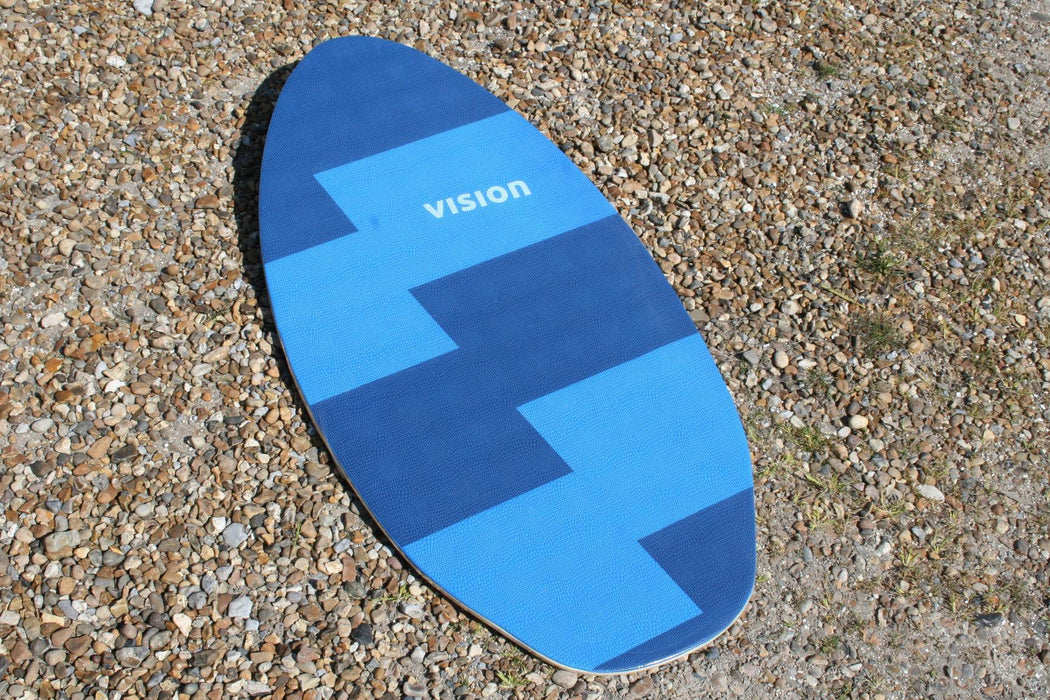 Vision Spark blue skimboard with zigzag pattern on pebbled beach