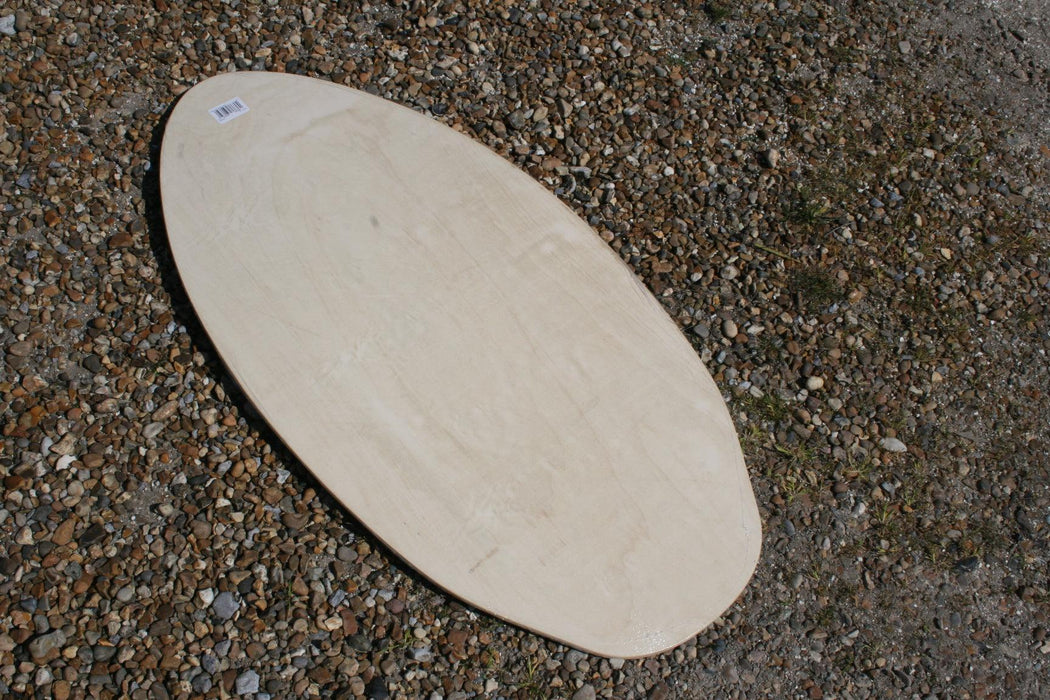 Vision Spark 41 skimboard, natural wood finish, flat oval shape on pebbled ground