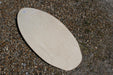 Vision Spark 41 skimboard, natural wood finish, flat oval shape on pebbled ground