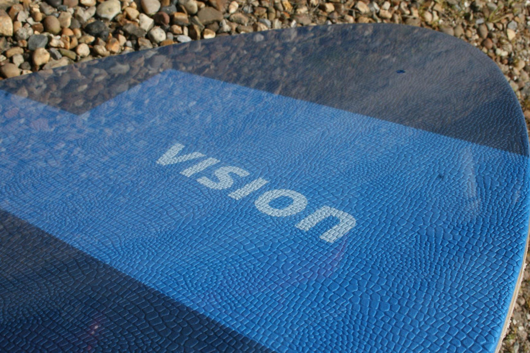 Vision blue skimboard with textured surface on pebbles, brand name visible.