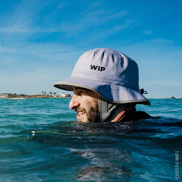 WIP grey surf hat worn by swimmer in the sea, protective shell hat for watersports