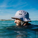 WIP grey surf hat worn by swimmer in the sea, protective shell hat for watersports